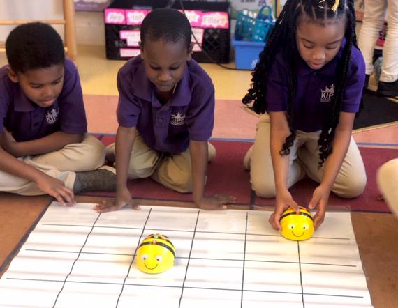 Three KLP students prepare to test their Bee Bots